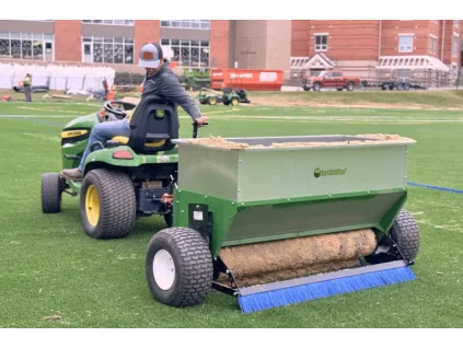 man spreading sand on a 54D spreader 1 768x512.png